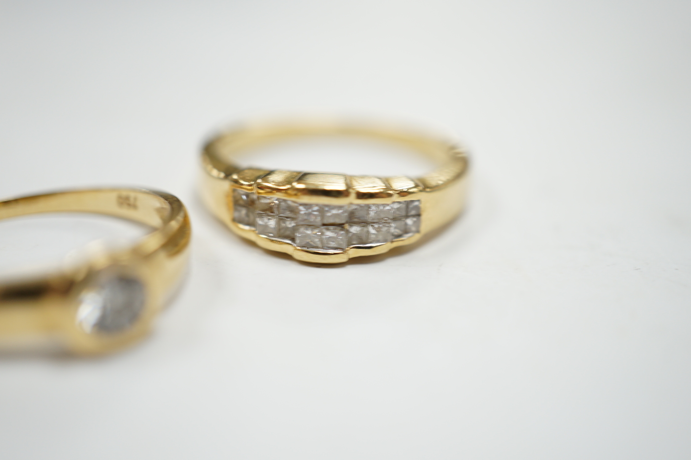 A 750 yellow metal and collet set solitaire diamond ring, size L and a yellow metal and diamond cluster set half hoop ring, size O, gross weight 7.4 grams
